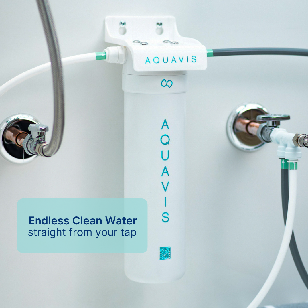 'A water filtration device labeled 'AQUAVIS' connected to pipes on a wall.'